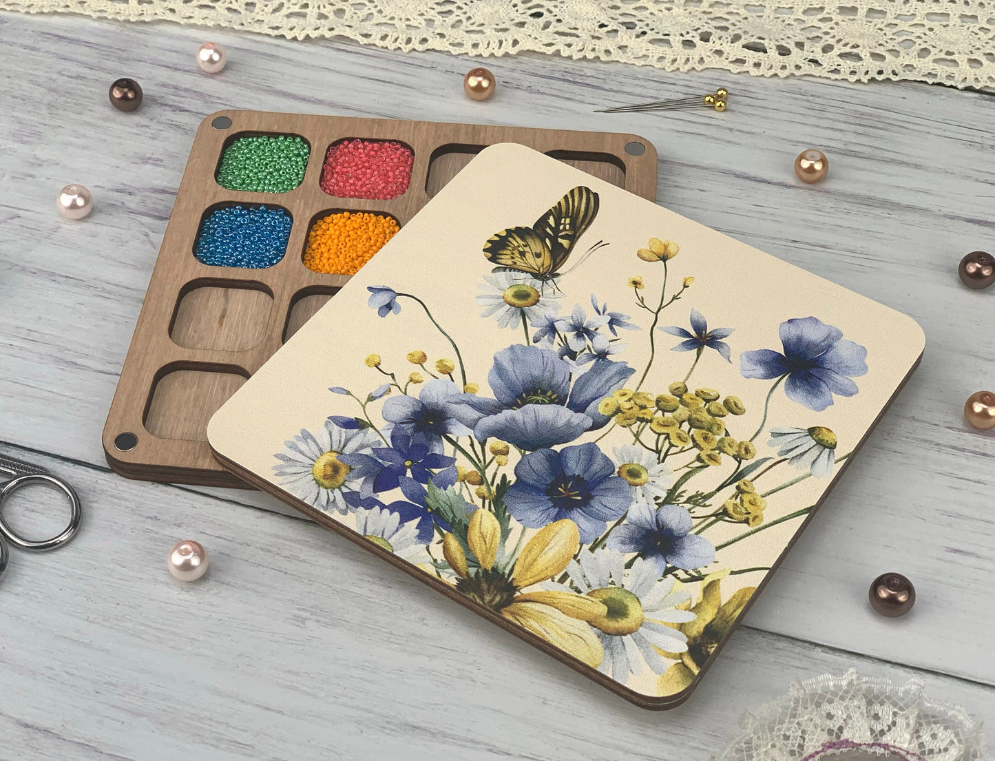 a wooden tray with a painting on it next to a pair of scissors