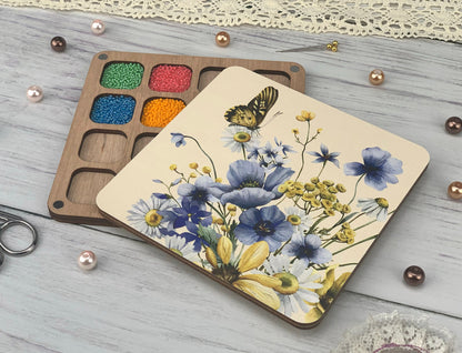 a wooden tray with a painting on it next to a pair of scissors
