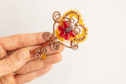 a person is holding a brooch in their hand