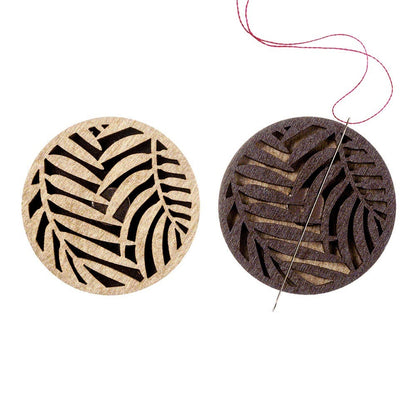 a pair of wooden coasters with a design of a leaf