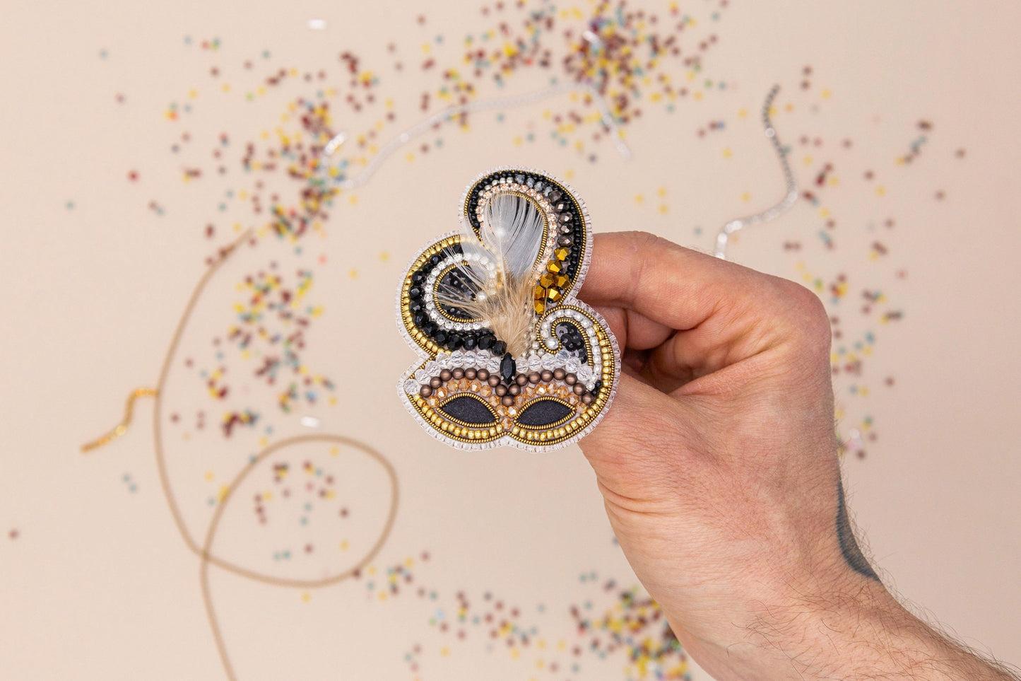 a hand is holding a brooch with a butterfly on it