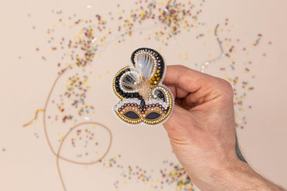 a hand is holding a brooch with a butterfly on it