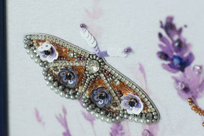 a close-up view of a butterfly-shaped piece of jewelry, adorned with various colorful beads, gemstones, and a crystal pendant.