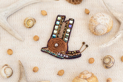 a picture of a beaded brooch with shells and seashells