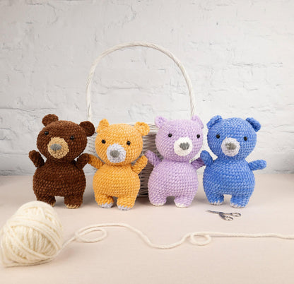 a group of stuffed animals sitting next to a ball of yarn