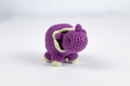 a small crocheted purple elephant toy on a white surface