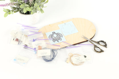 a crafting area with various supplies and materials, including a wooden board, scissors, and a potted plant.