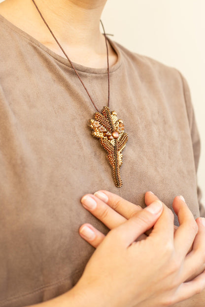 a woman wearing a necklace with a flower on it