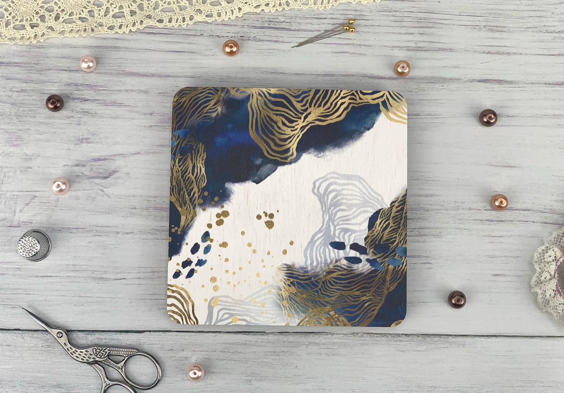 a white table with a pair of scissors and a notebook on it