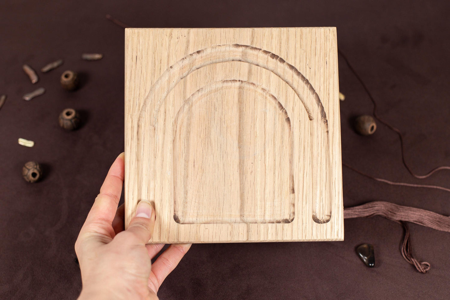 a person holding a wooden block with a design on it