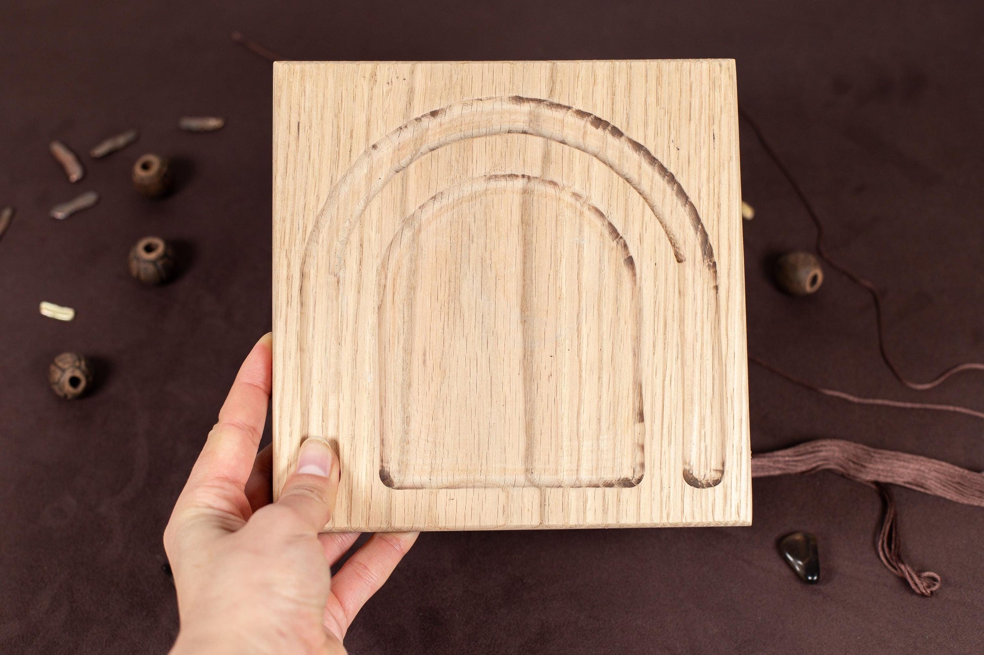 a person holding a wooden block with a design on it