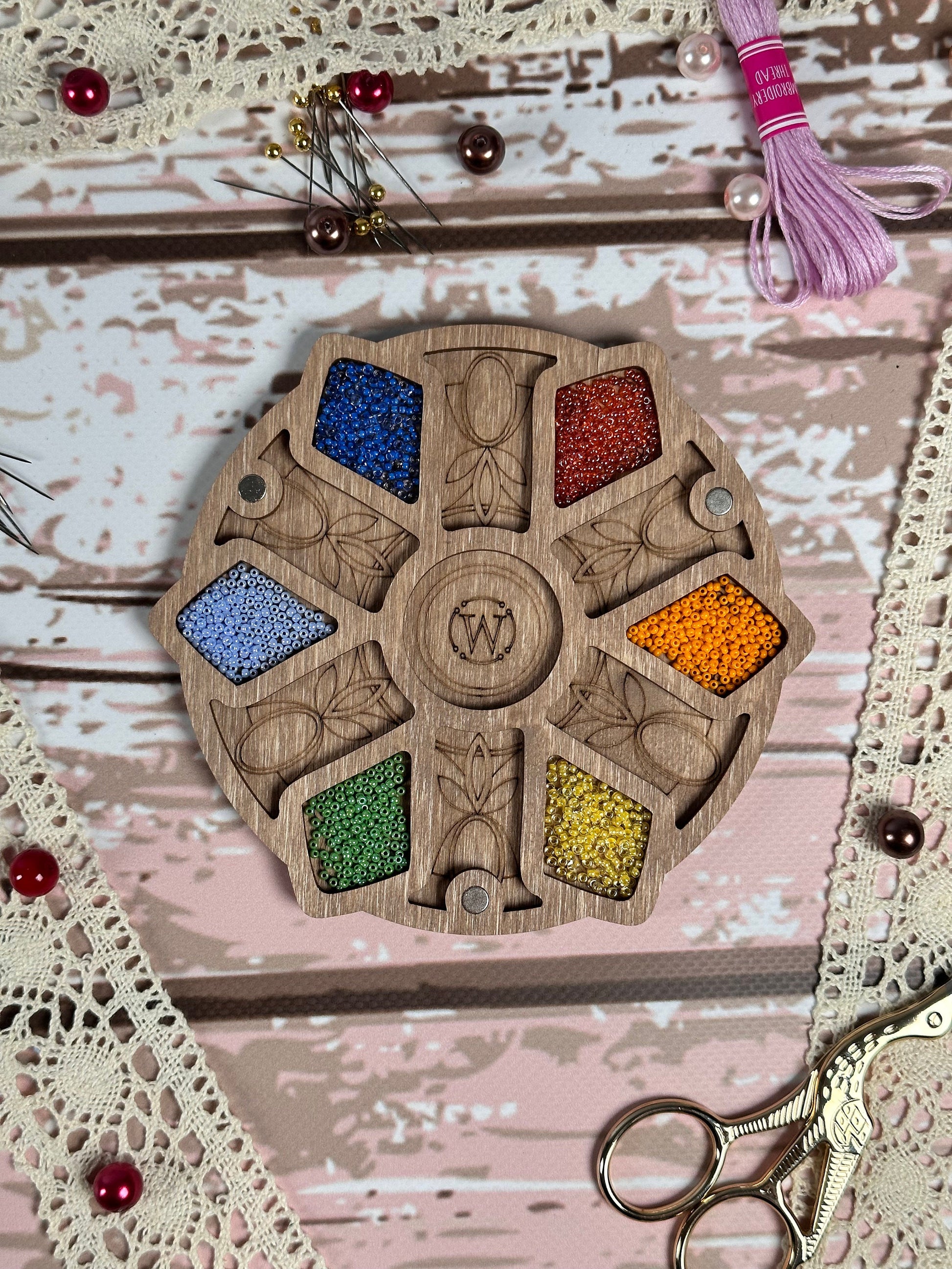a picture of a wooden wheel with beads and a pair of scissors