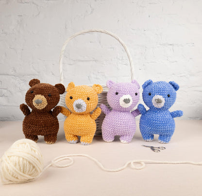 a group of stuffed animals sitting next to a ball of yarn
