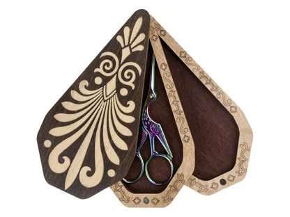 a pair of scissors sitting inside of a wooden case