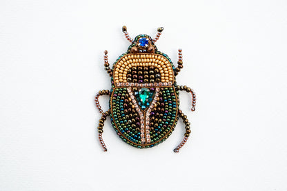 a beaded beetle sitting on top of a white surface