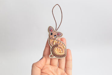 a hand holding a beaded animal ornament