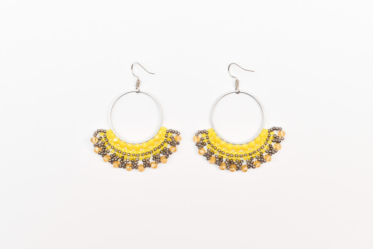 A pair of earrings with a yellow and black color scheme, featuring a circular design with a beaded or sequined trim.