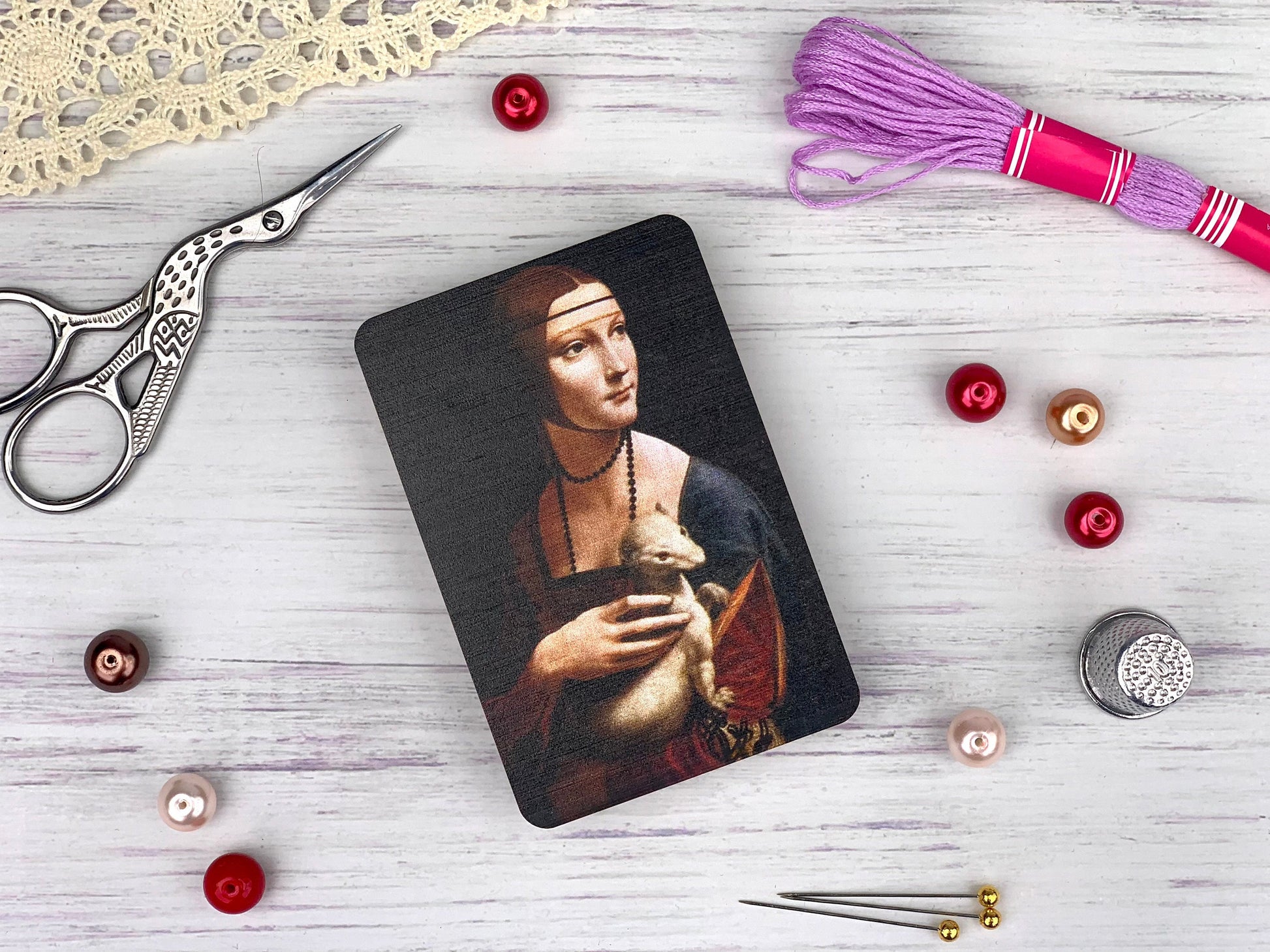 a picture of a woman holding a cat next to a pair of scissors