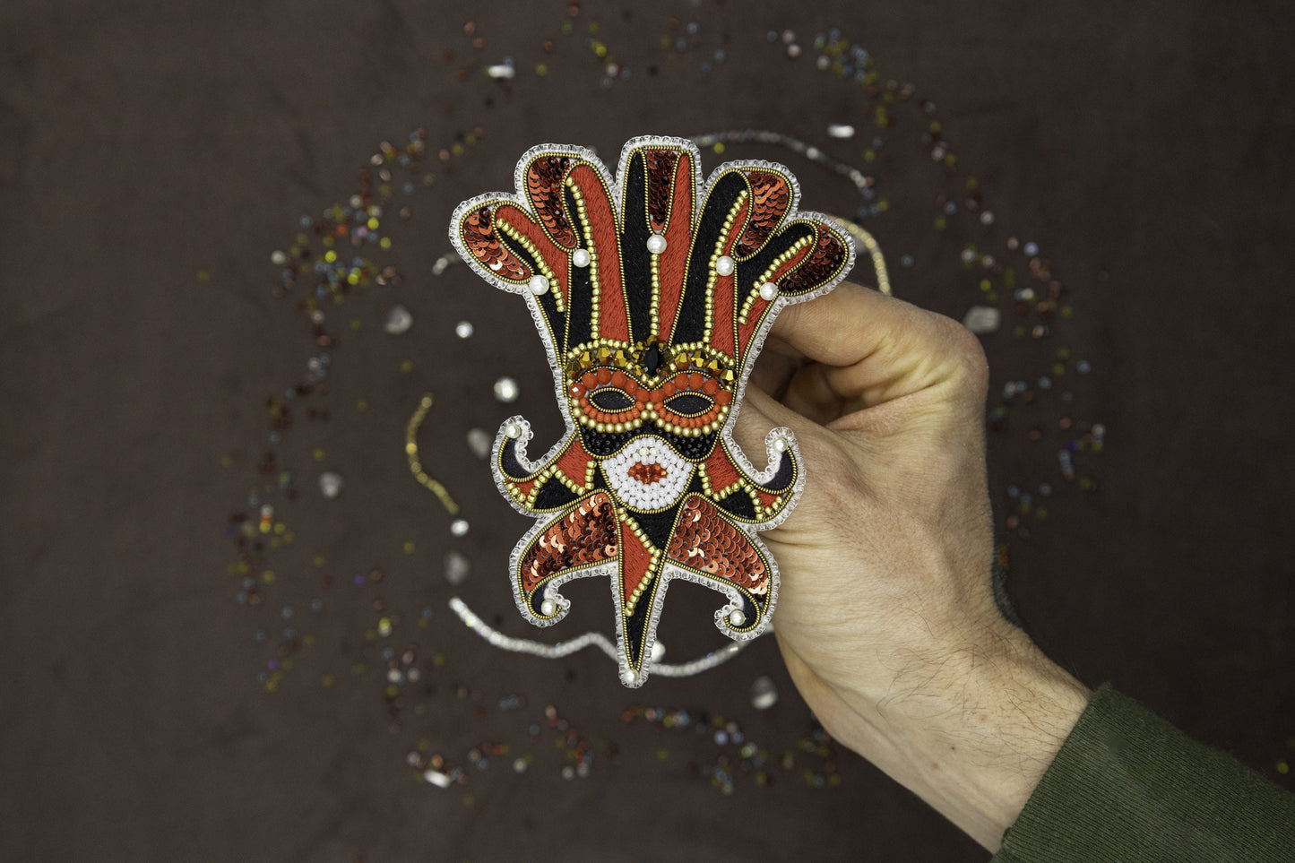 a hand holding a sticker with a mask on it