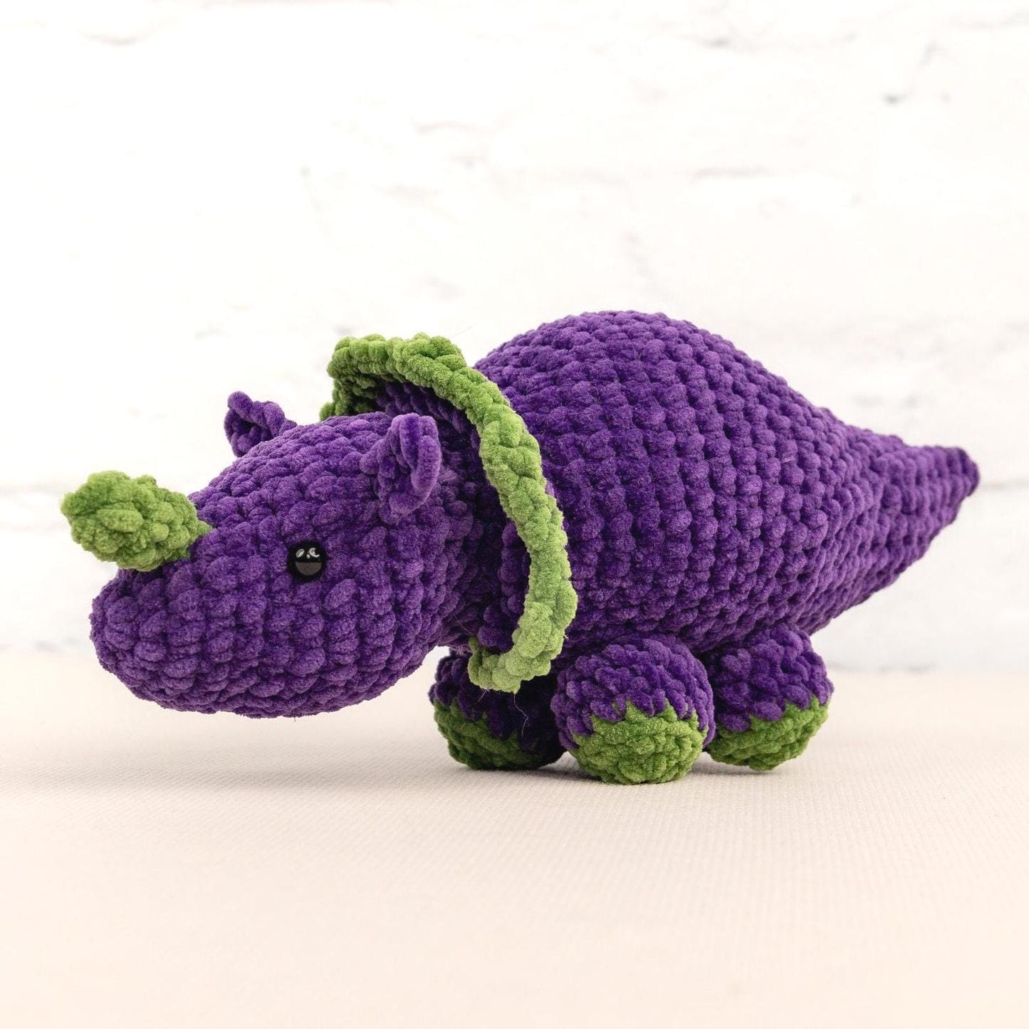 a crocheted purple and green stuffed animal