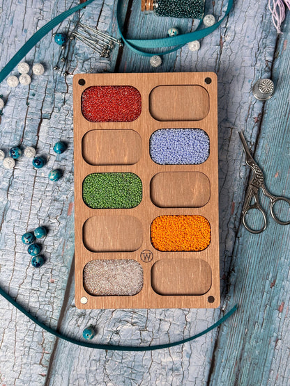 a wooden box filled with different colored beads