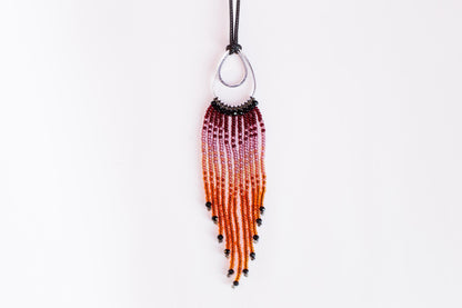 A beaded necklace with a long, tassel-like design hanging from a black cord.