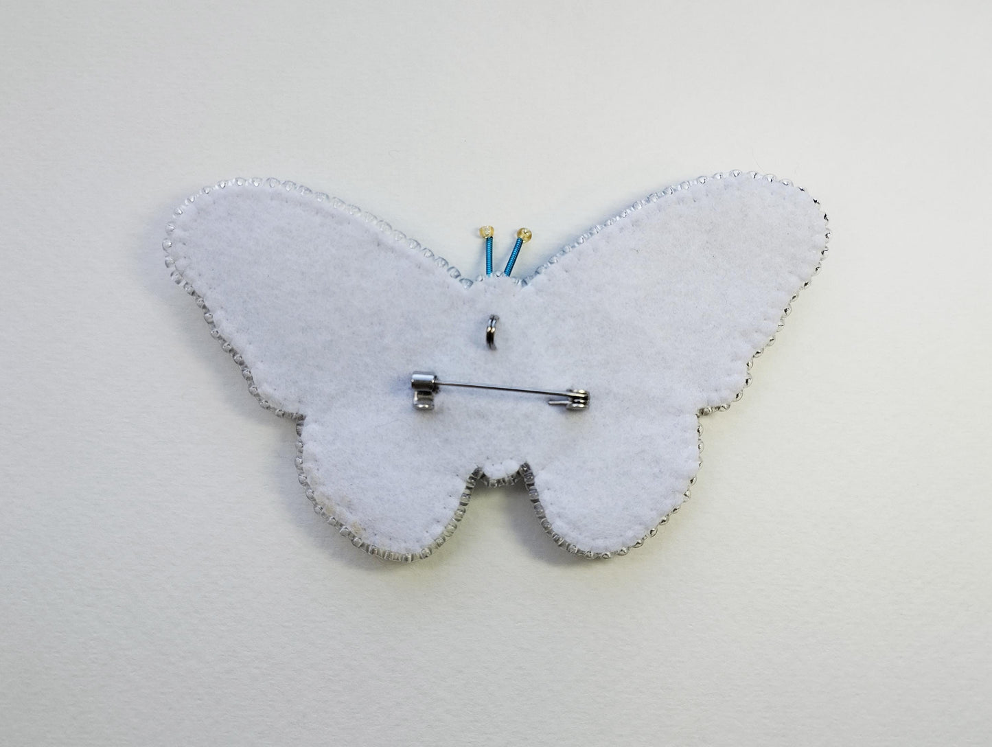 a white clock with a butterfly design on it