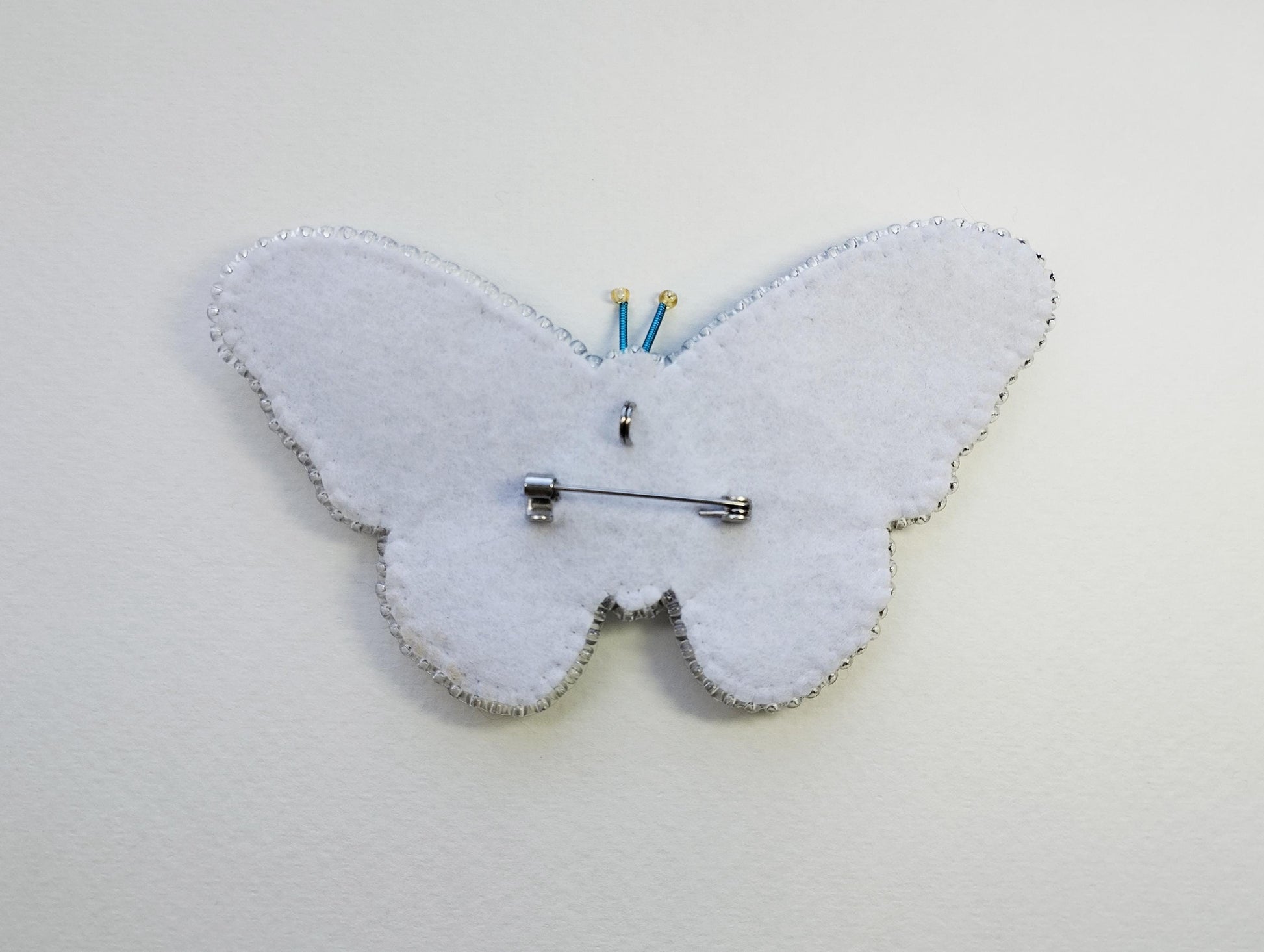 a white clock with a butterfly design on it
