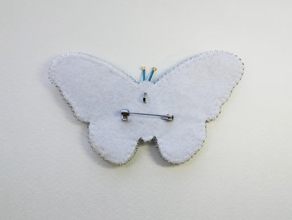 a white clock with a butterfly design on it