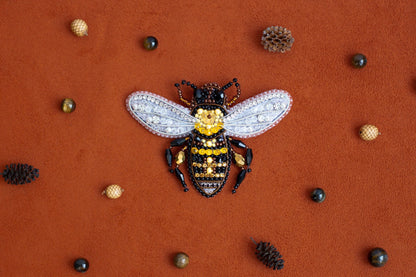 a yellow and black bee sitting on top of a red surface