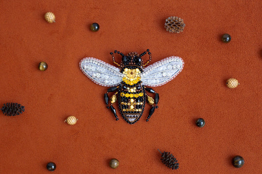 a yellow and black bee sitting on top of a red surface