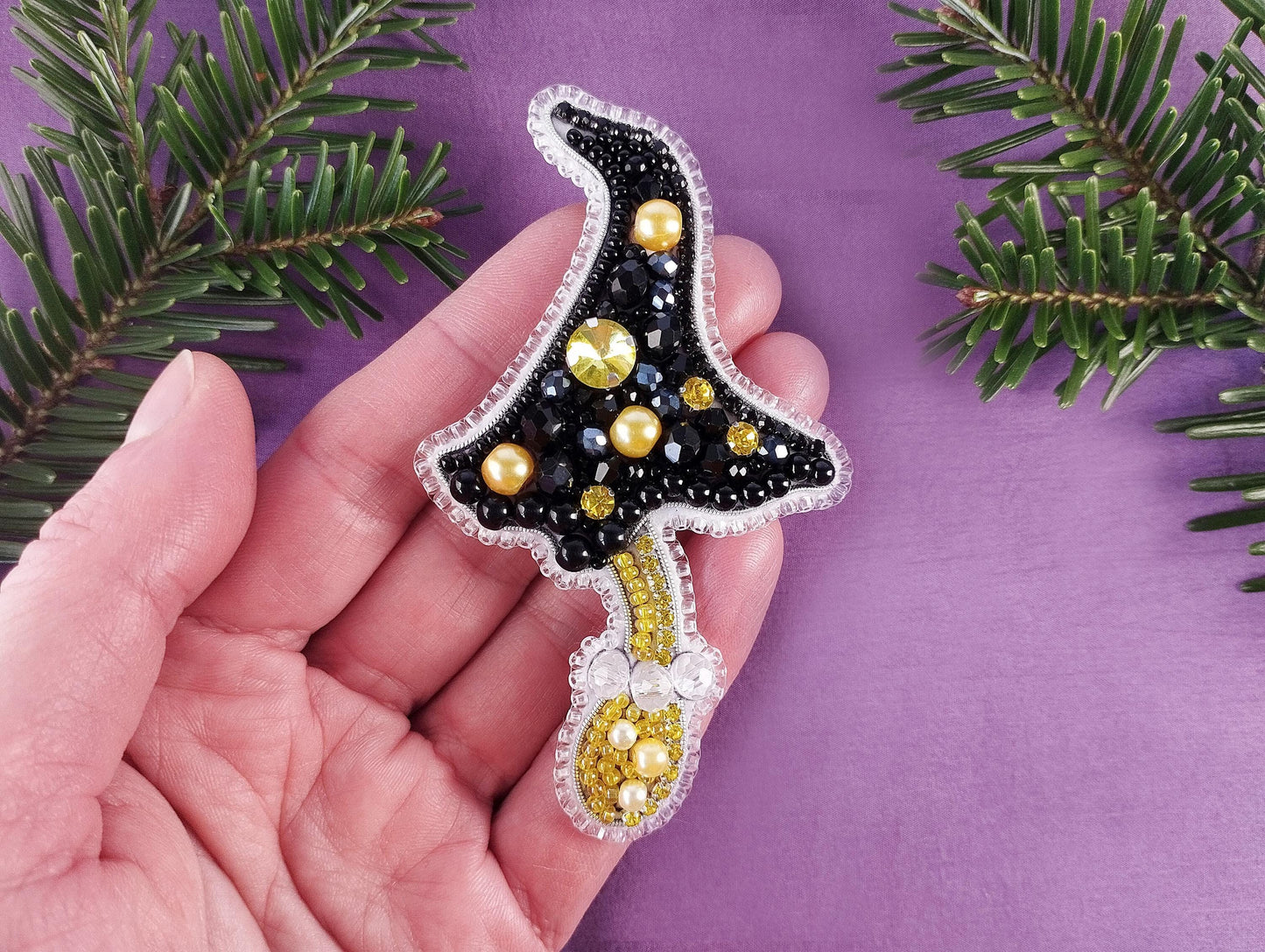 a hand holding a christmas ornament on a purple background
