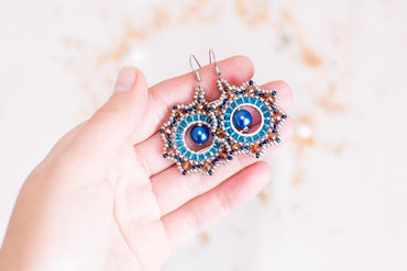 a person holding a pair of earrings in their hand