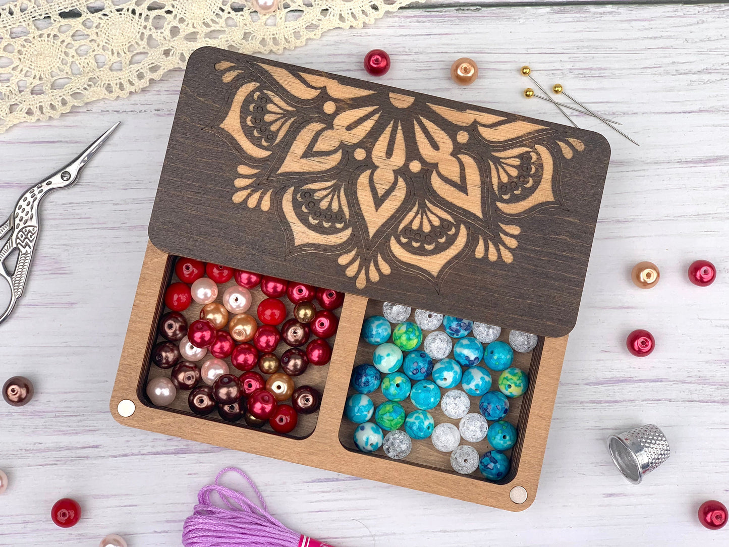 a box of beads and a pair of scissors on a table
