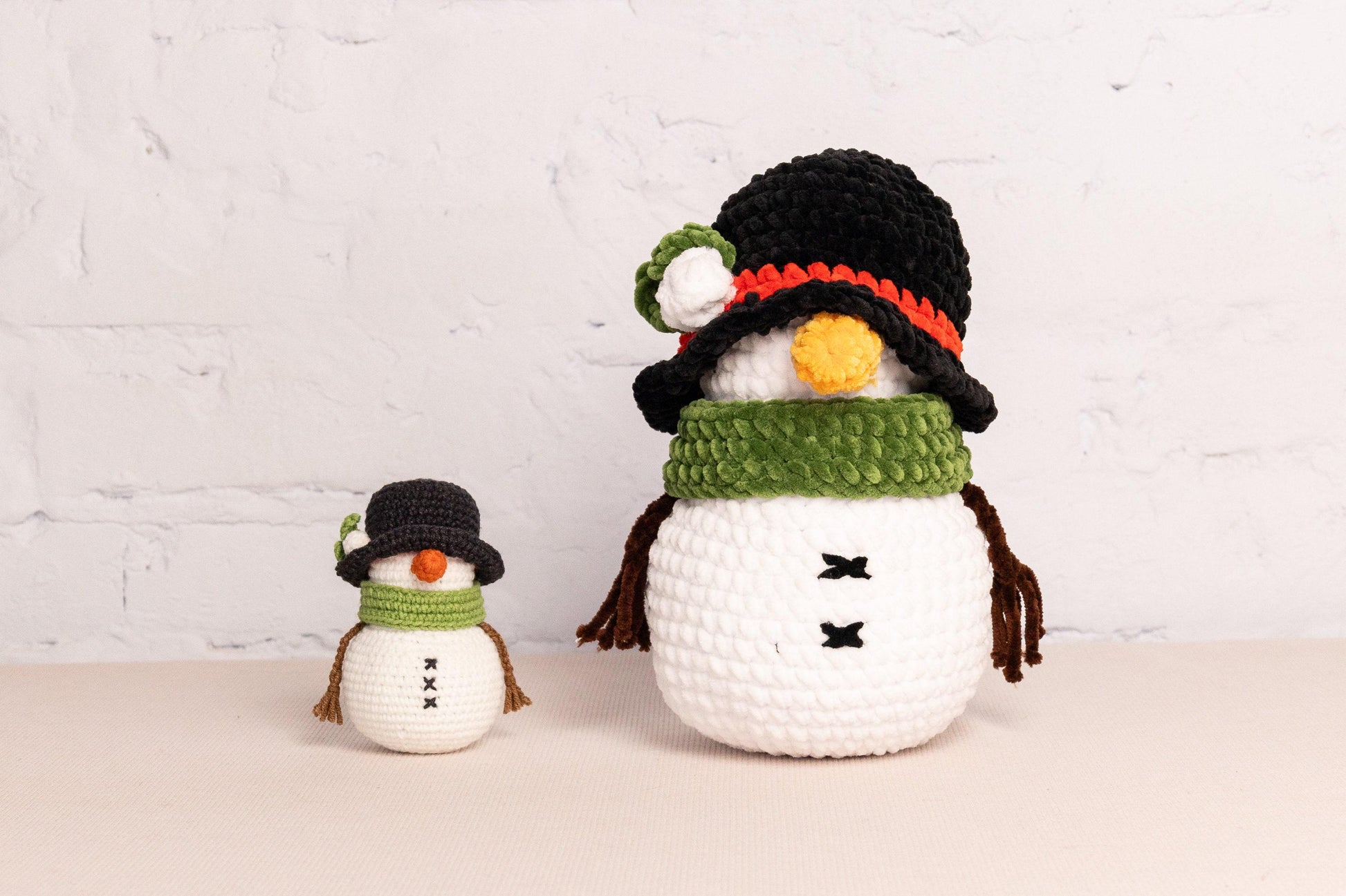 a hand holding a small crocheted snowman