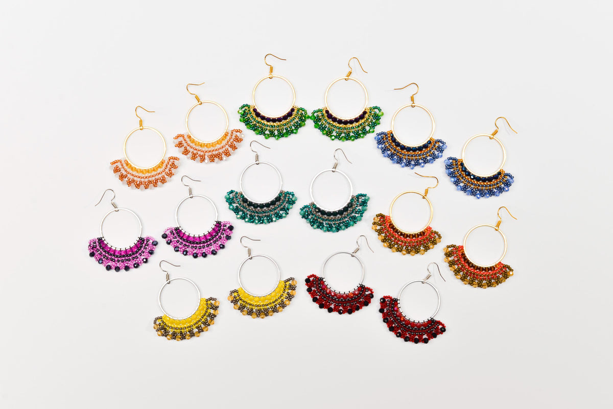 A collection of colorful earrings with various designs and patterns, arranged in a grid-like pattern against a white background.