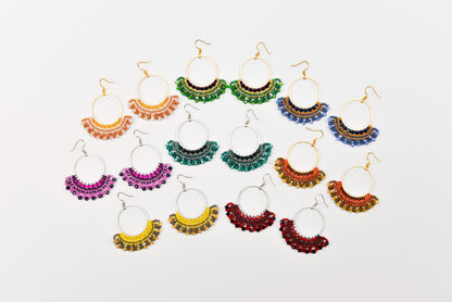 A collection of colorful earrings with various designs and patterns, arranged in a grid-like pattern against a white background.