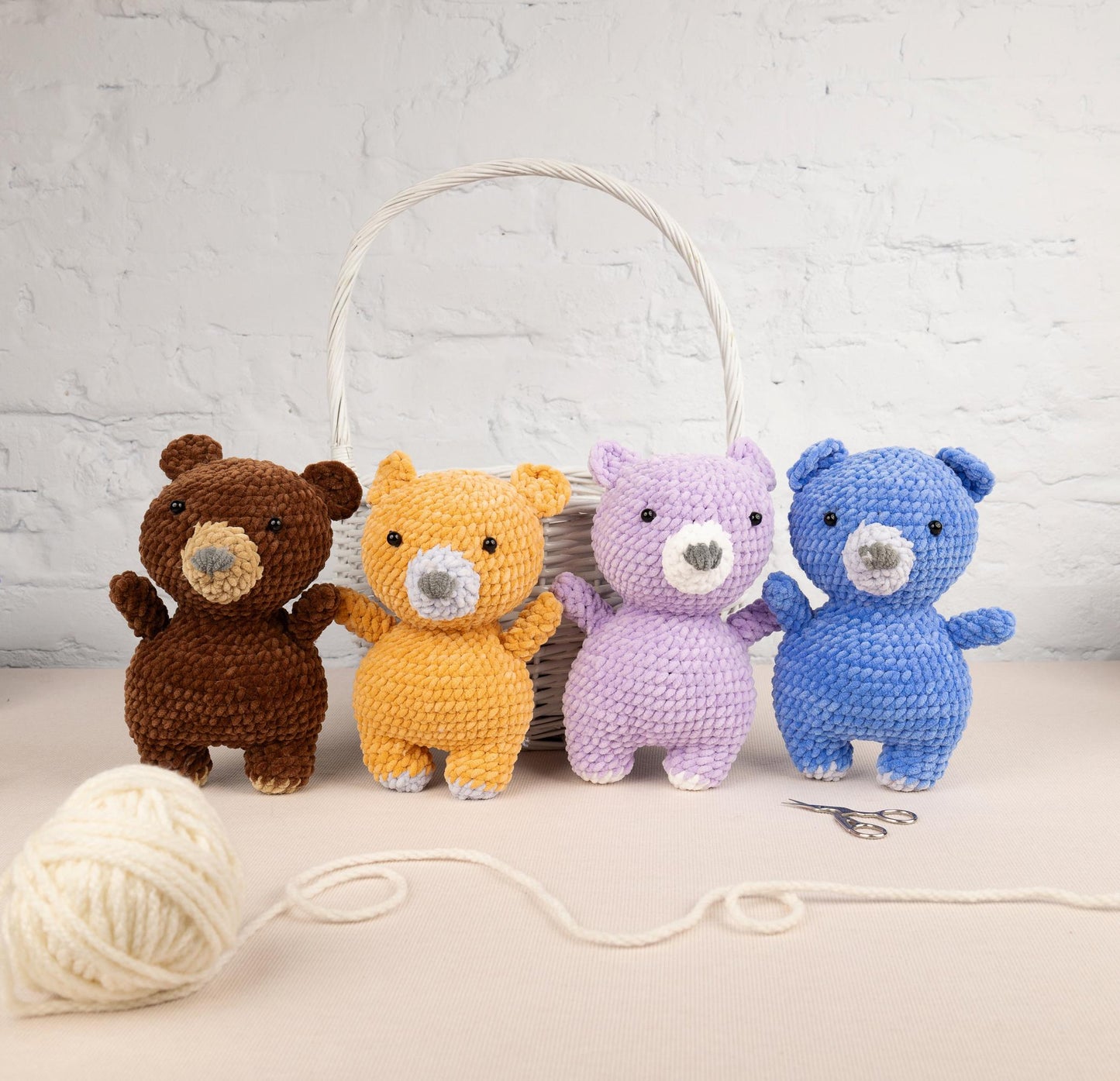 a group of stuffed animals sitting next to a ball of yarn