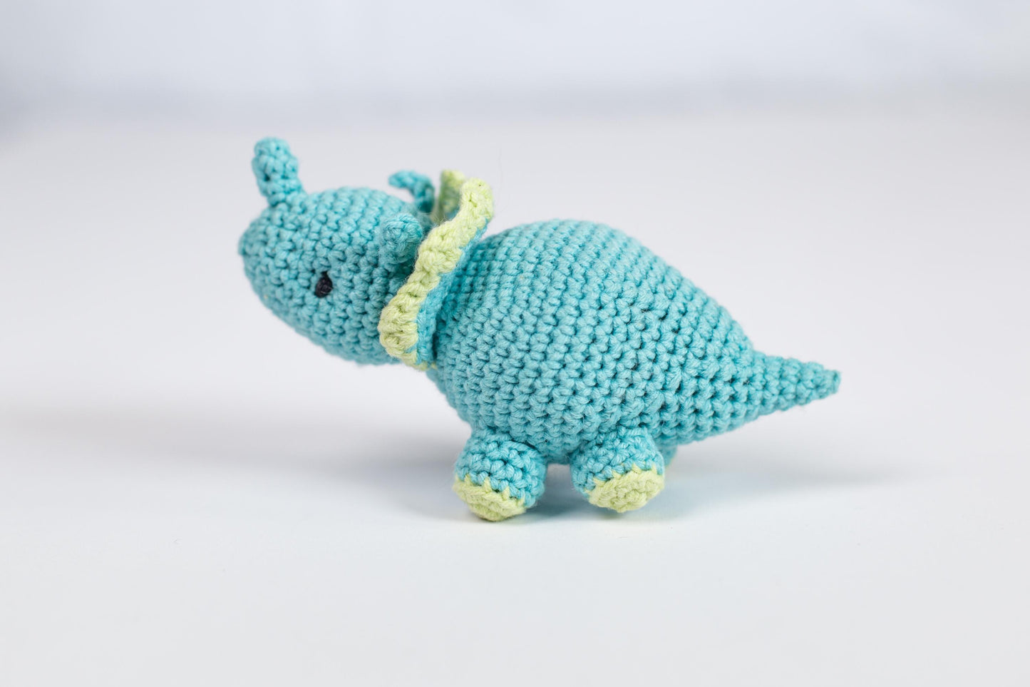 a crocheted stuffed animal with a yellow ribbon around its neck