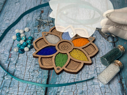 a hand is holding a piece of wood with beads and beads on it