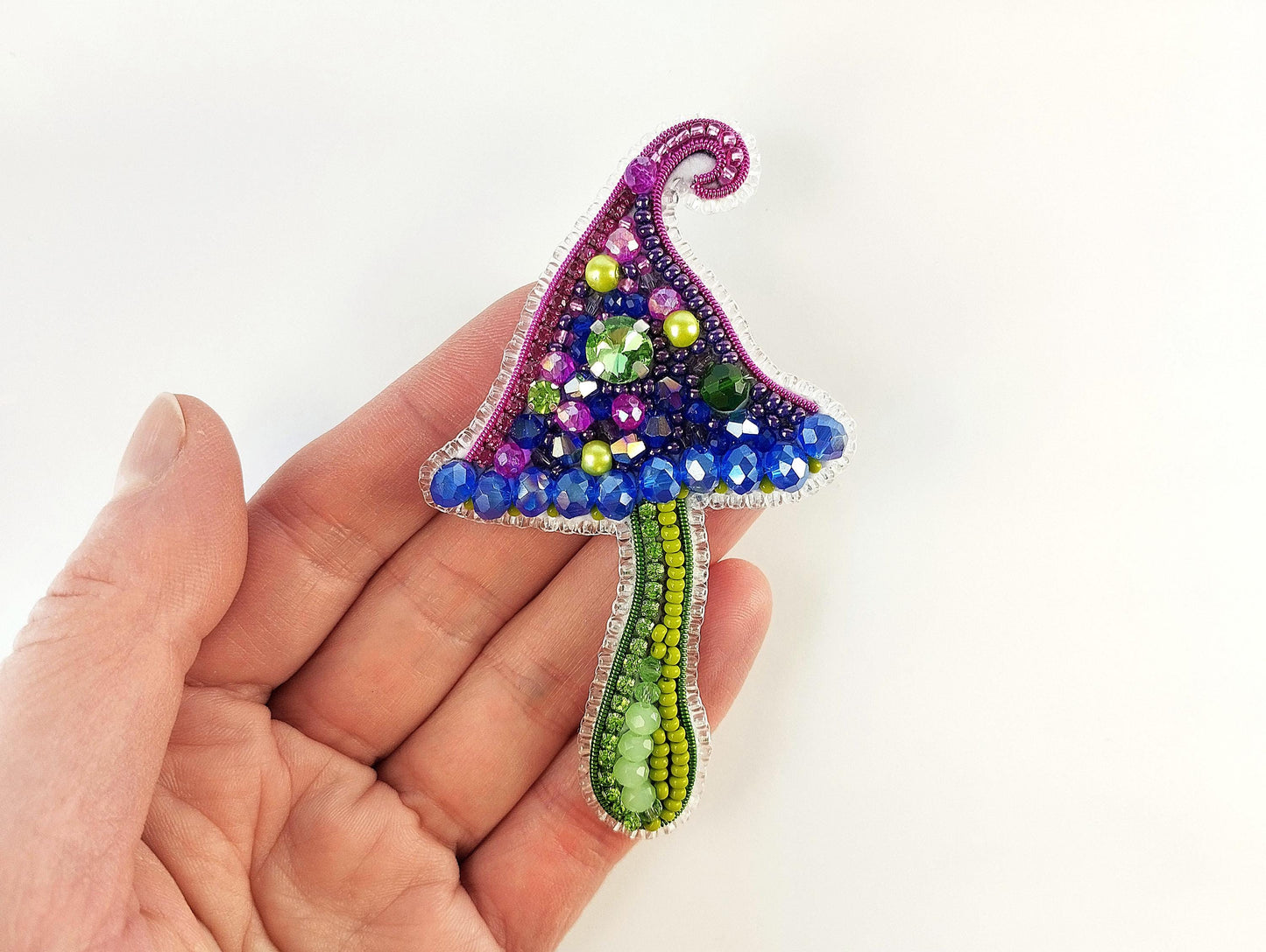 a hand holding a small colorful object in it&#39;s palm