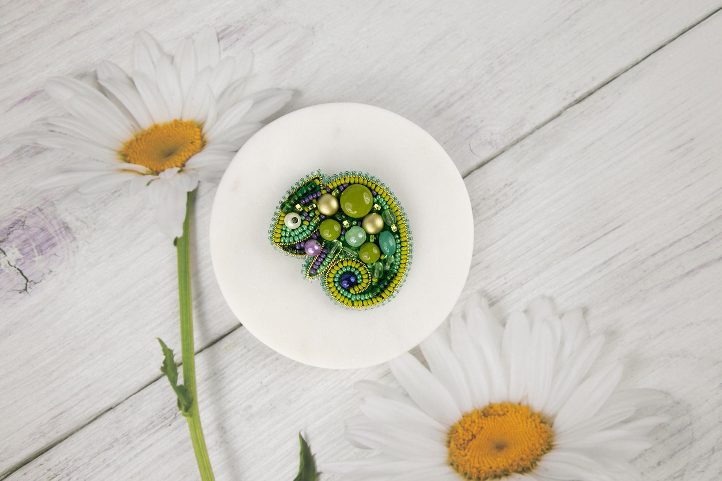 a white plate with a green beaded lizard on it