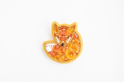 a beaded brooch with a fox design on it