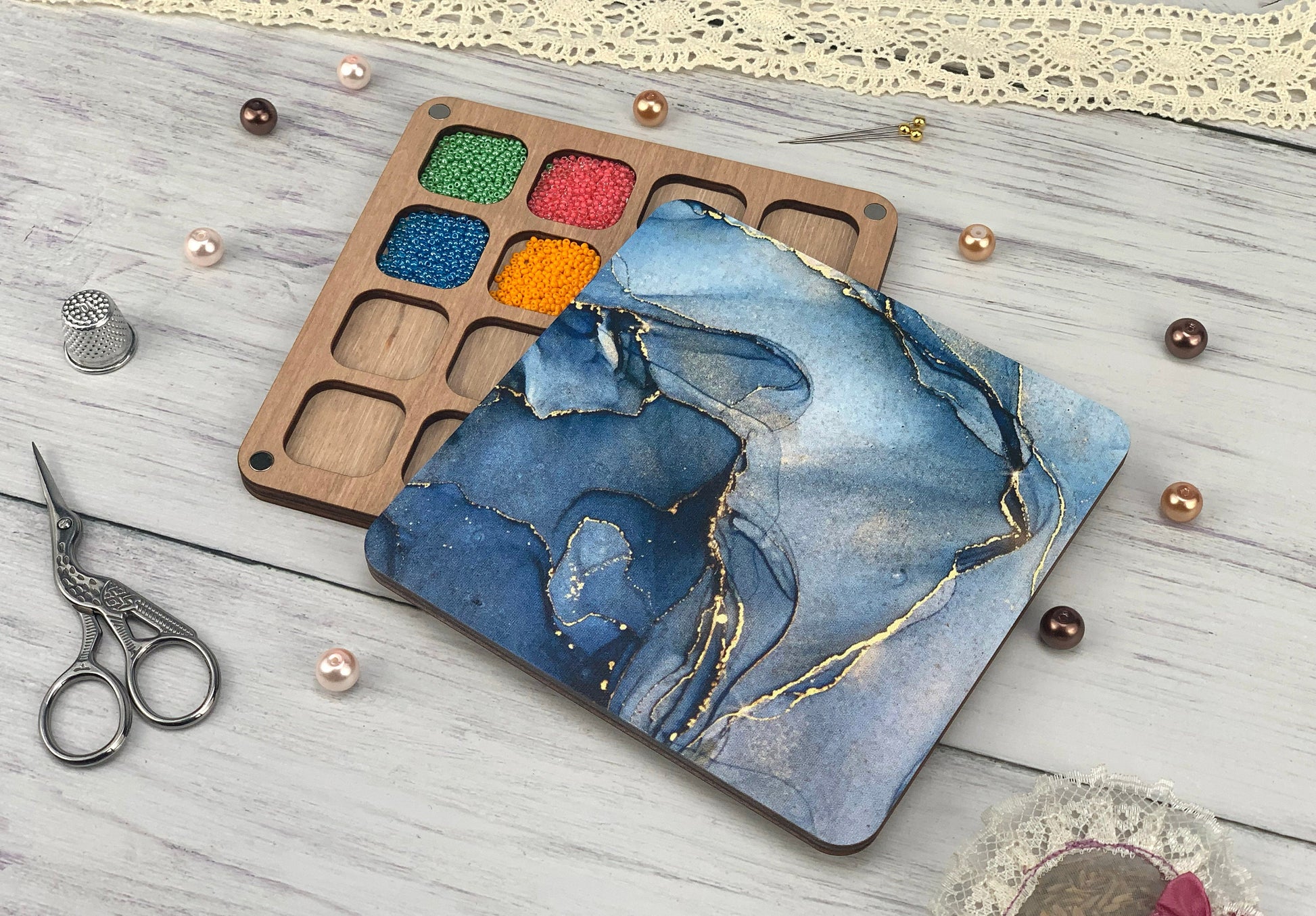 a wooden tray with paint and scissors on a table