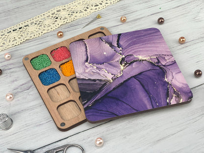 a wooden tray with a painting on it next to a pair of scissors