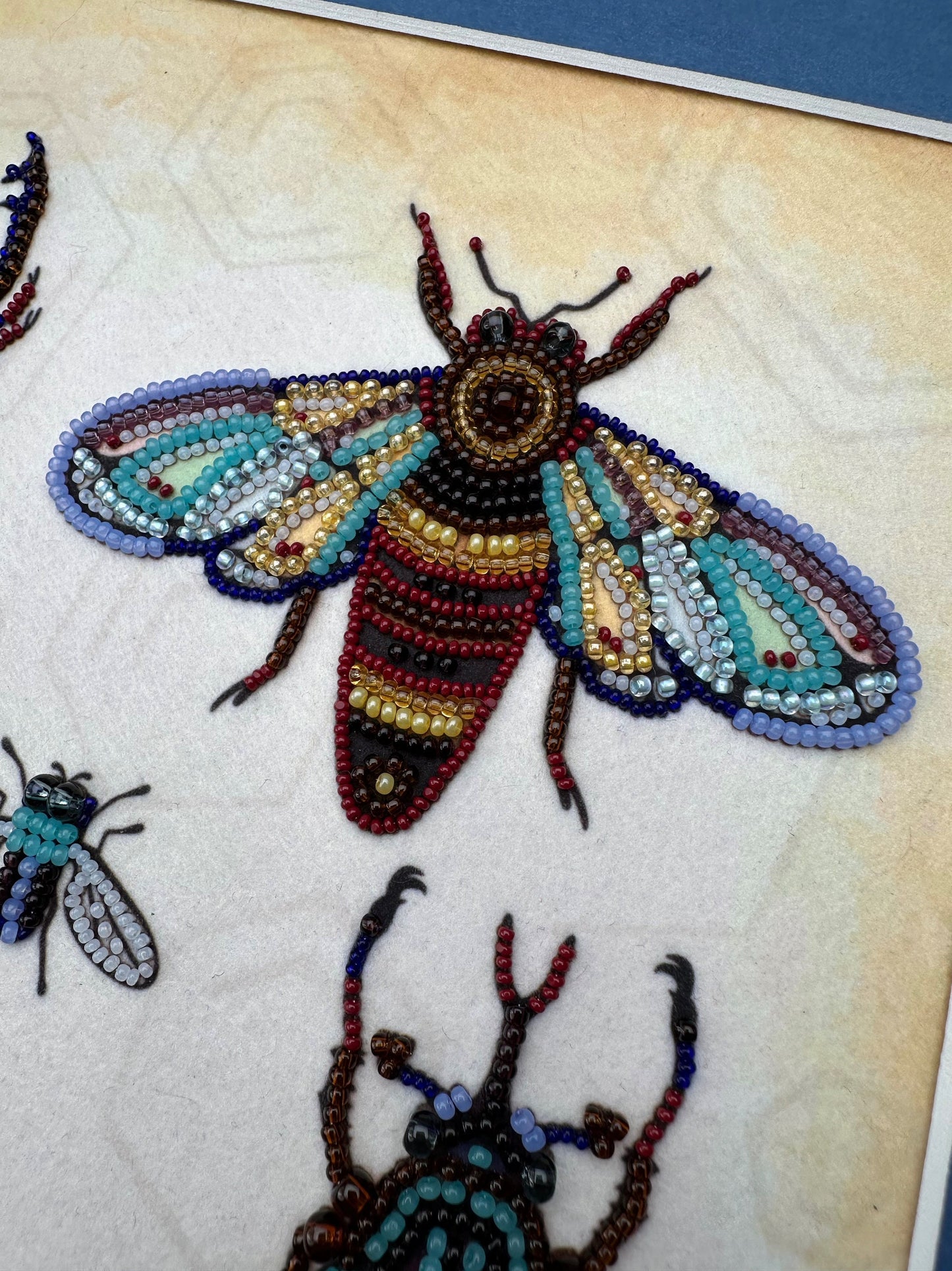 a picture of some beaded bugs on a piece of cloth