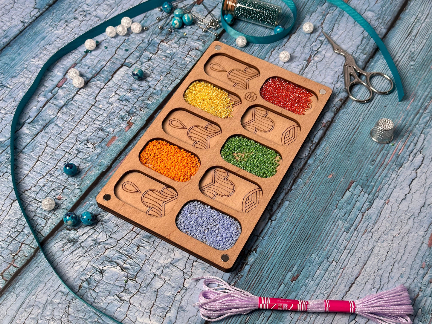 a wooden tray filled with different colored beads