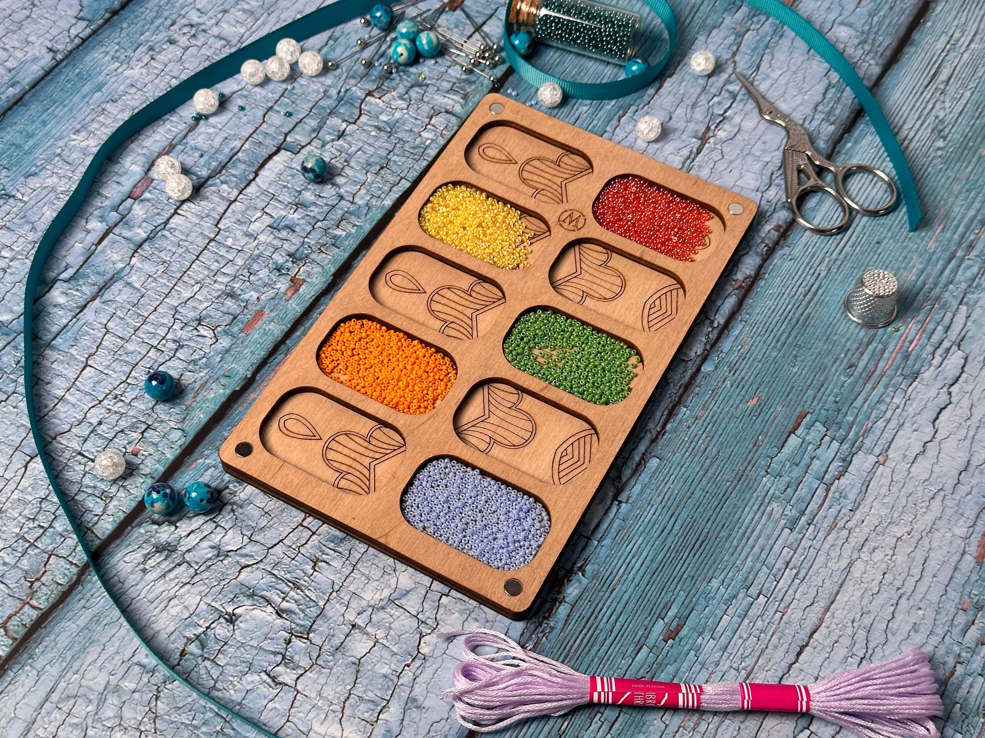 a wooden tray filled with different colored beads