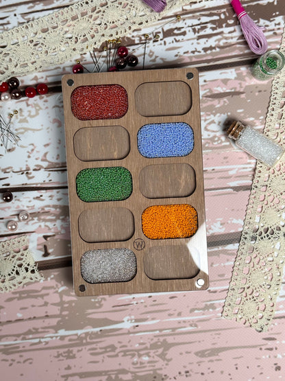 a wooden box filled with lots of different colored beads