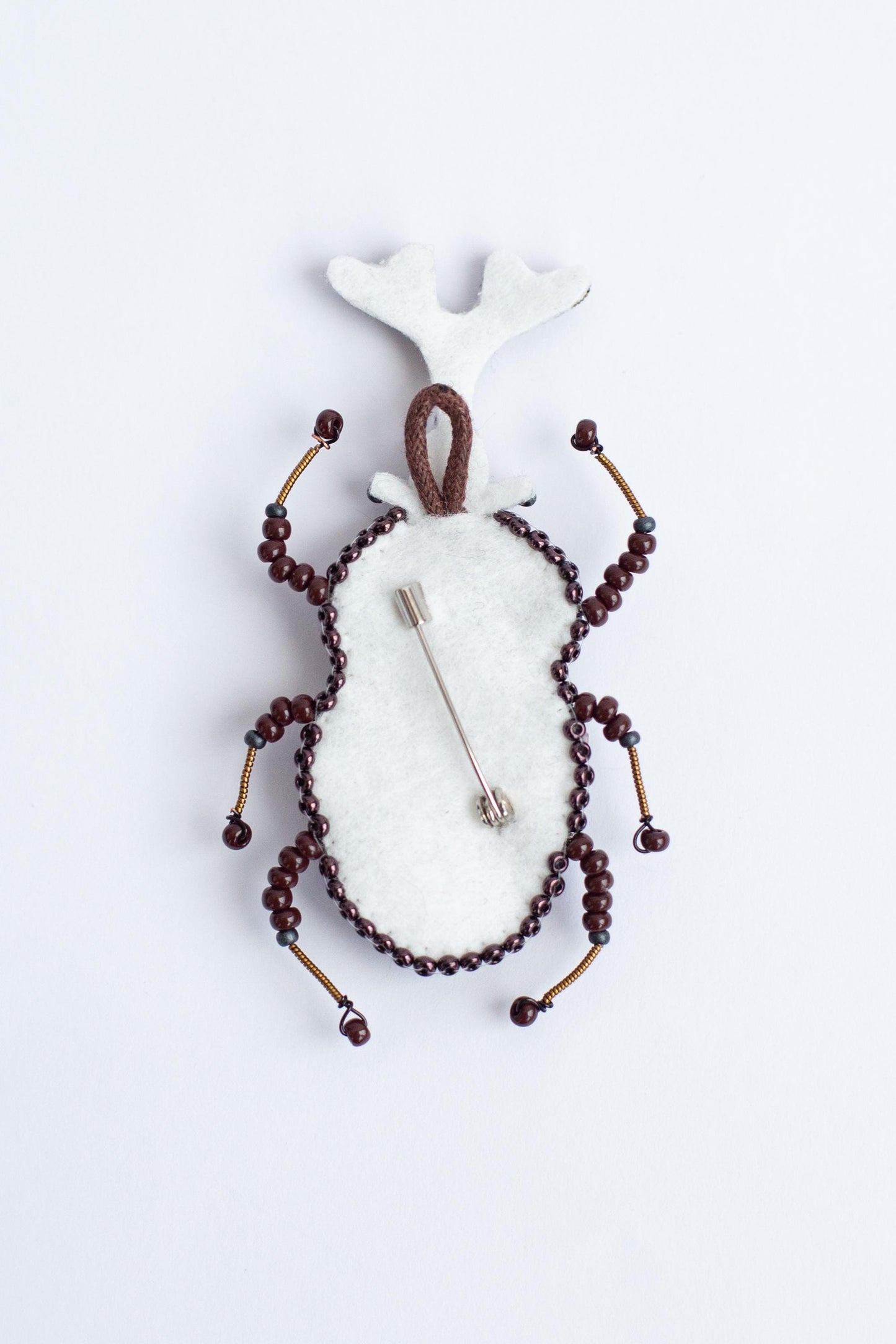 a brooch with beads and a deer head